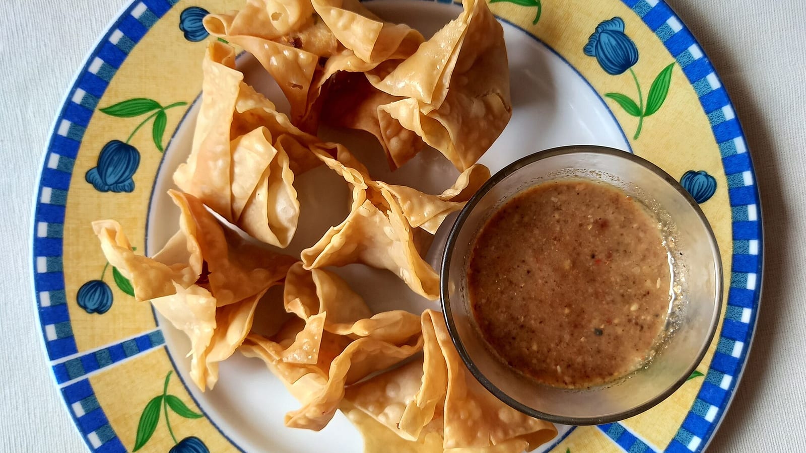 Batagor Bandung goreng renyah dengan cocolan saus kacang cokelat di piring