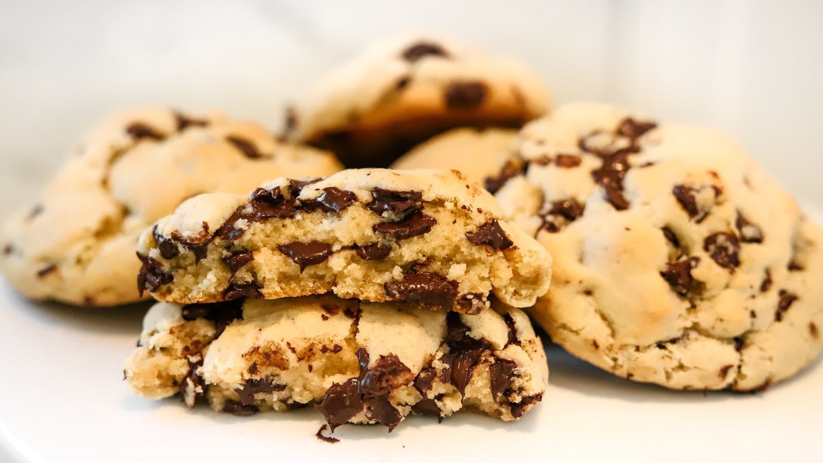 Chocolate chip cookies lembut dengan satu dipatahkan menampakkan cokelat meleleh
