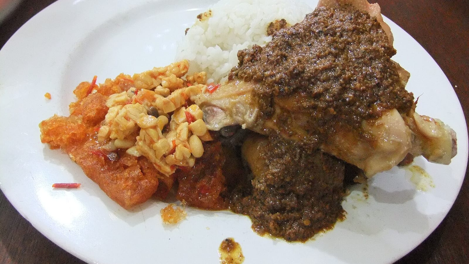Nasi gudeg Jogja: nangka muda dengan areh kental, ayam, dan sambal krecek di piring putih