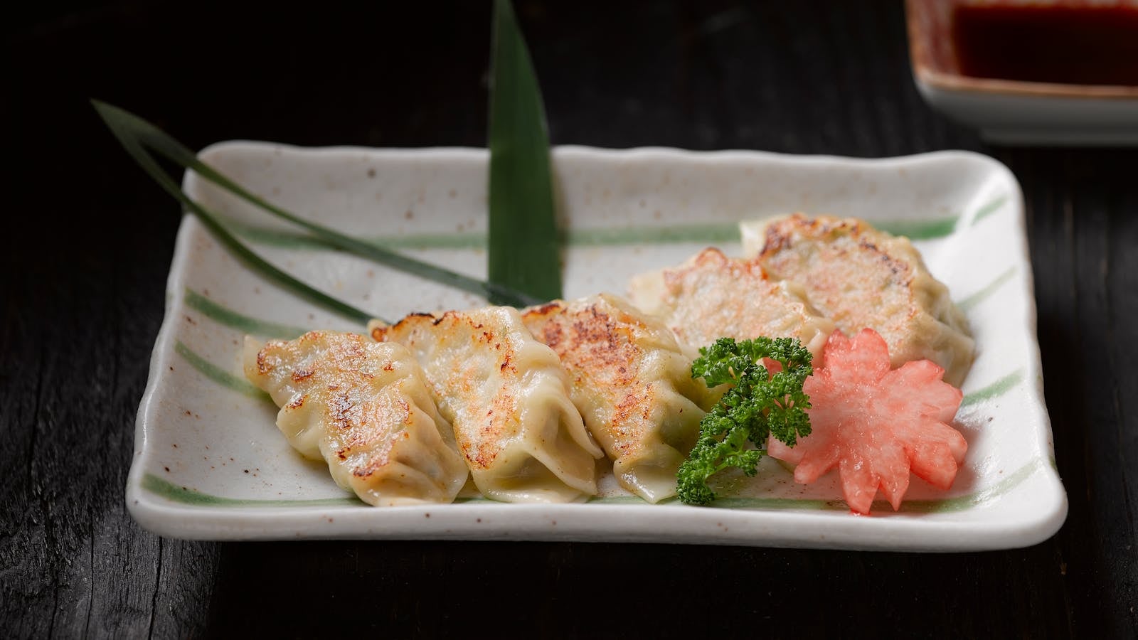 Gyoza pan-fried dengan kulit coklat keemasan crispy disajikan di piring
