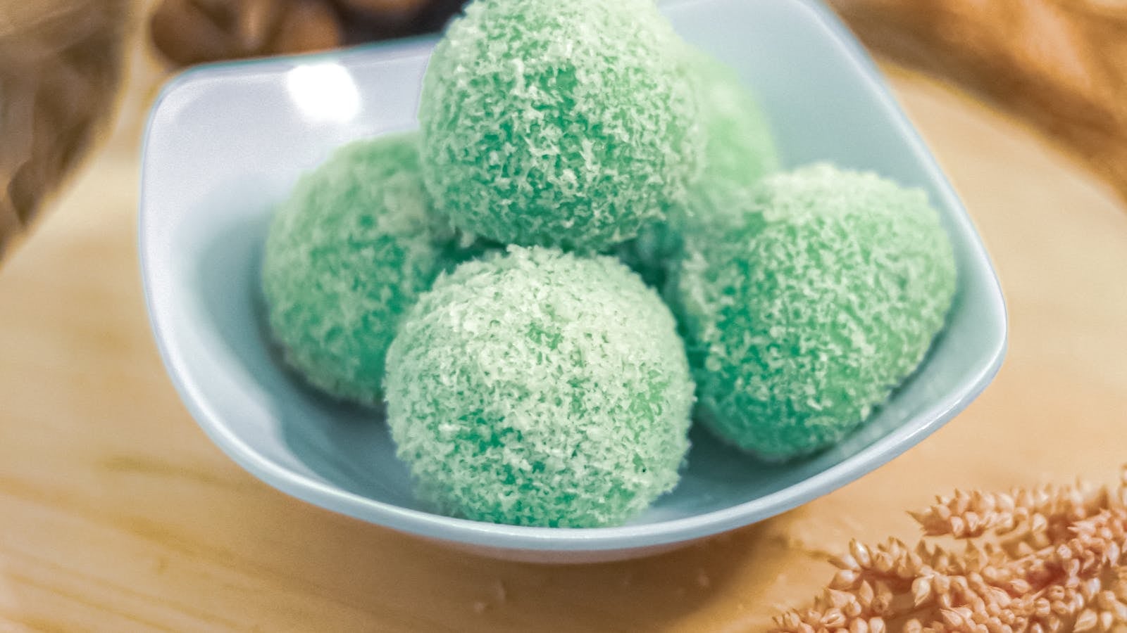 Resep klepon pandan hijau berlapis kelapa parut di atas talenan kayu