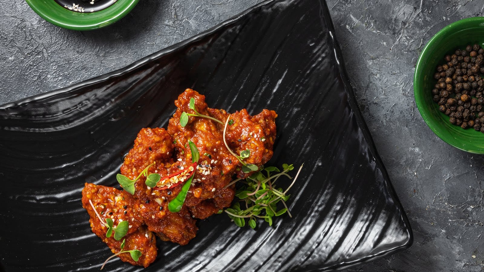 Korean fried chicken berbalut glazur gochujang merah mengkilap dengan taburan wijen