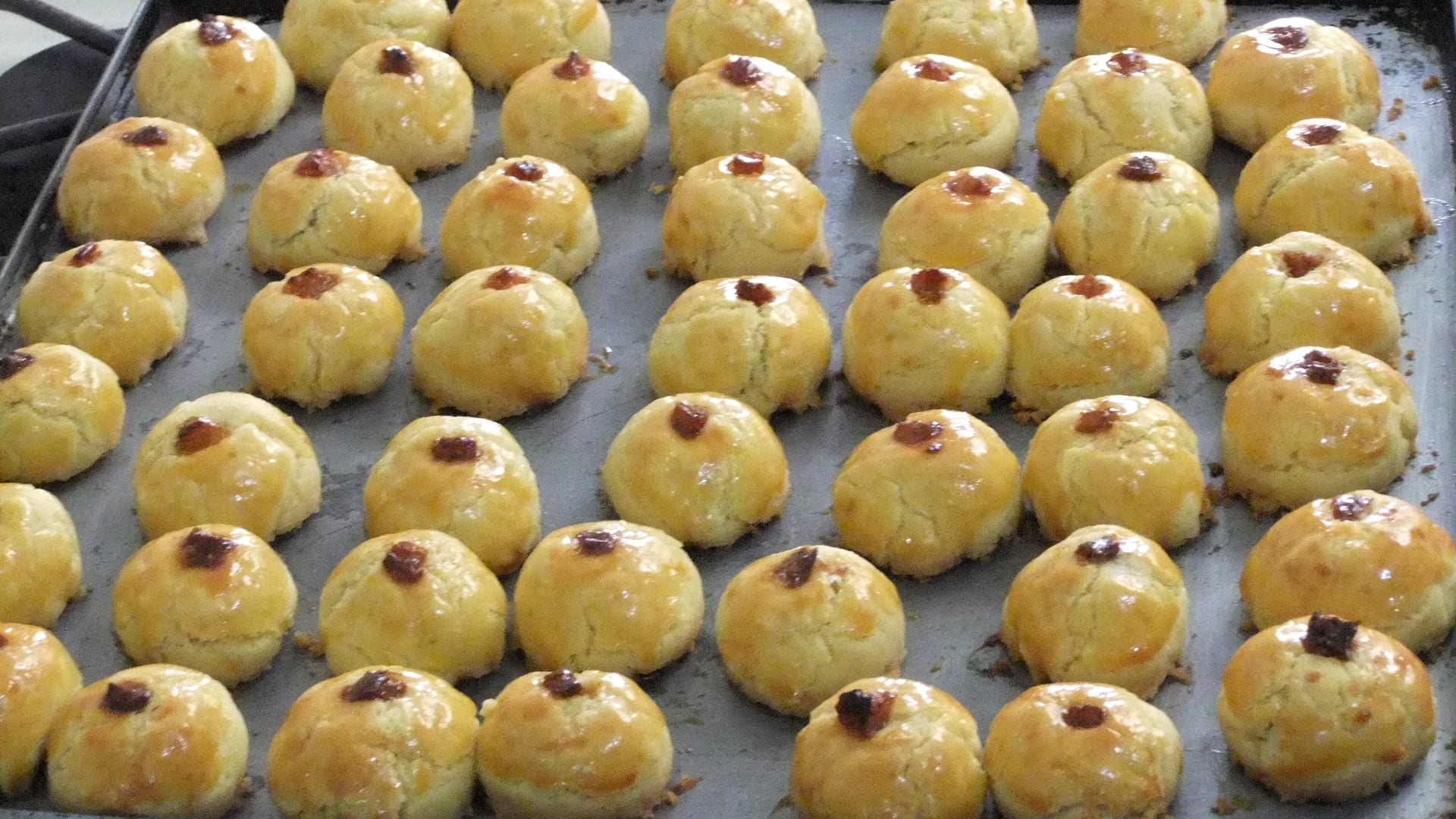 Nastar nanas keemasan mengkilap dengan olesan kuning telur, berbaris di loyang panggang