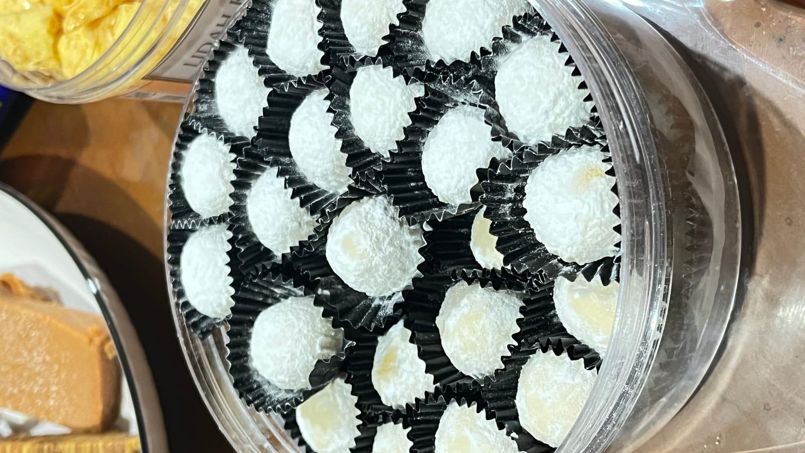 Putri salju bentuk bulan sabit berselimut gula halus tebal dalam cup kertas hitam