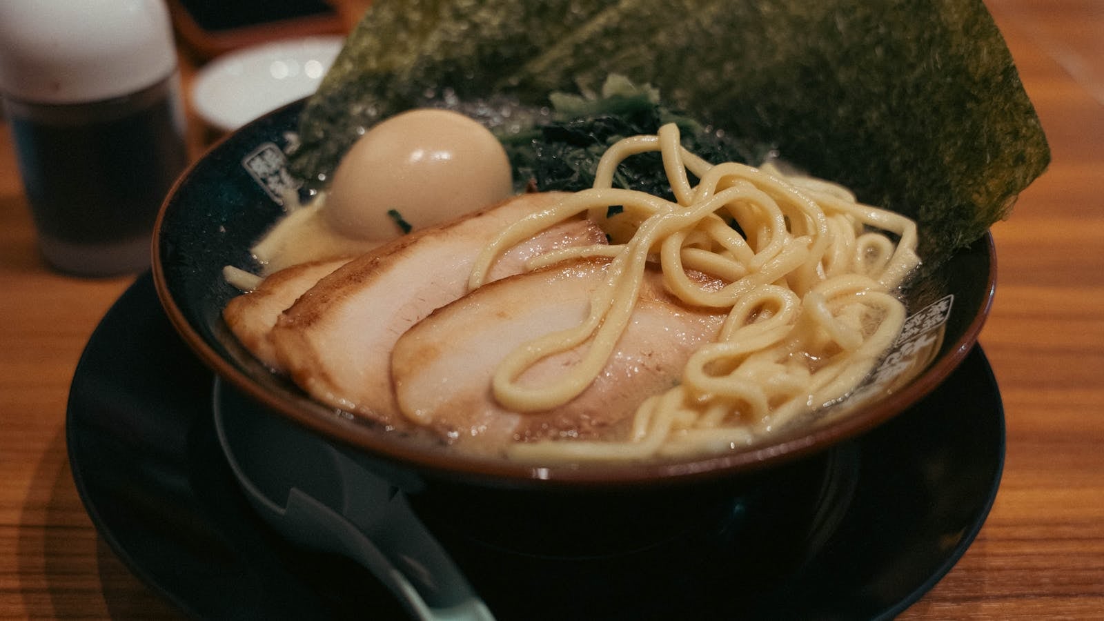 Mangkuk ramen panas dengan mie, telur, nori, dan kuah kaya