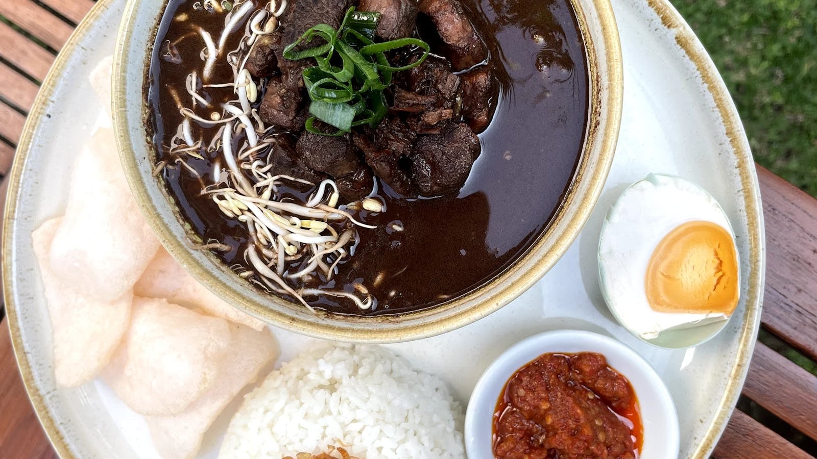 Semangkok rawon Surabaya kuah hitam dengan daging sapi, tauge pendek, dan nasi putih