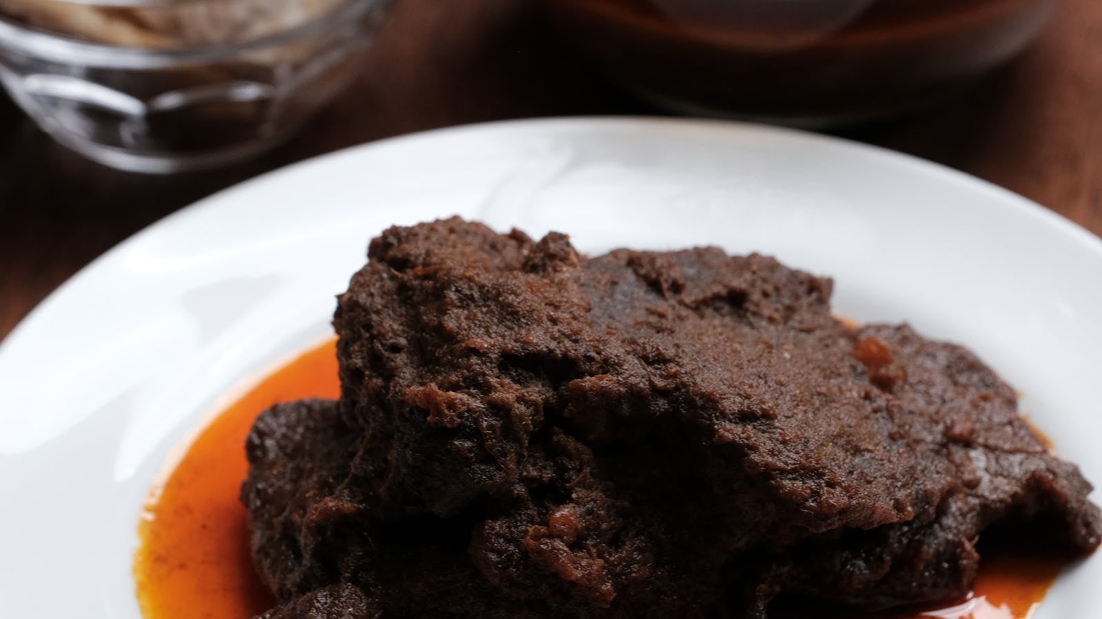 Rendang daging sapi dengan irisan cabai di piring putih