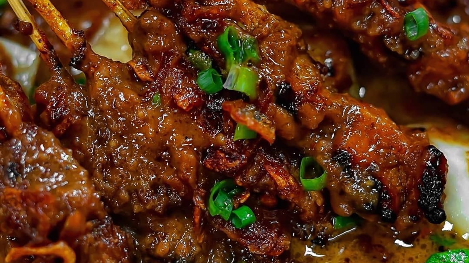 Sate ayam Madura dengan bumbu kacang dan taburan bawang goreng